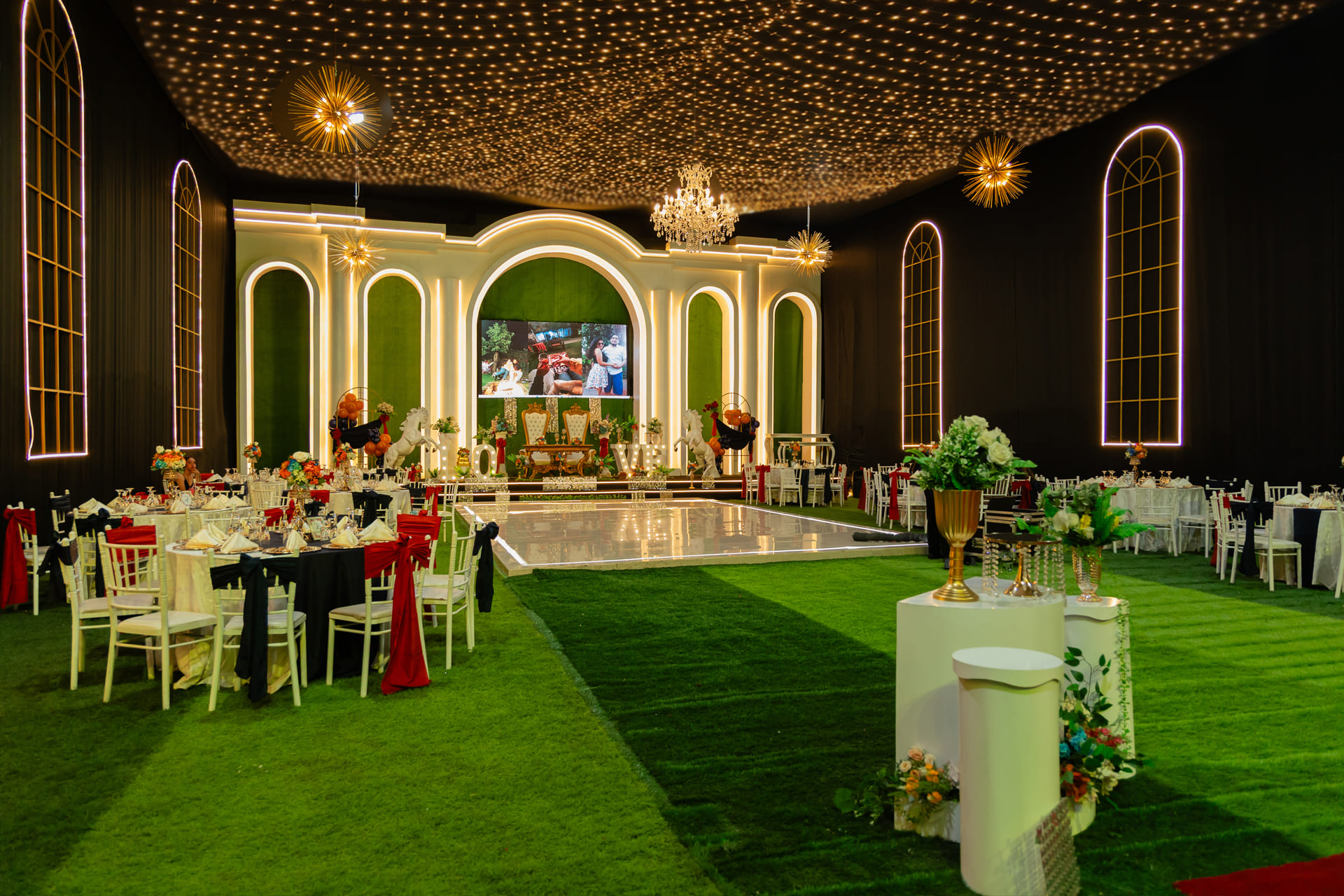 Salón de eventos decorado con luces y mesas elegantes